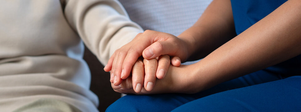 With empathetic and caring attention, professional nurses hold the hands of elderly patients to comfort and encourage them, while also offering advice on healthcare.