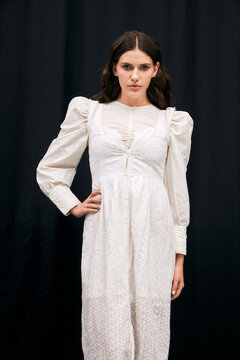 Elegant young woman showcases sophisticated fashion in striking white attire