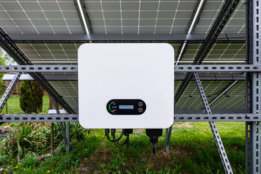Solar inverter converting energy from photovoltaic panels in garden
