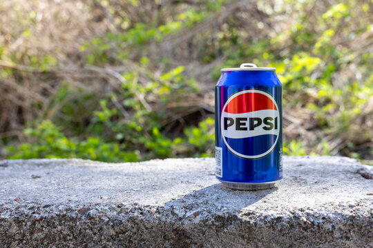 Pepsi can placed on a concrete surface outdoors with green natural background and copy space in daylight. Baltiysk, Kaliningrad region, Russia. May 2, 2026