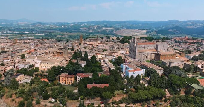 Aerial view Orvieto Italy historic city on tuff plateau. Iconic Duomo cathedral medieval architecture lush green gardens mountains background. Summer travel tourism destination drone photography explo