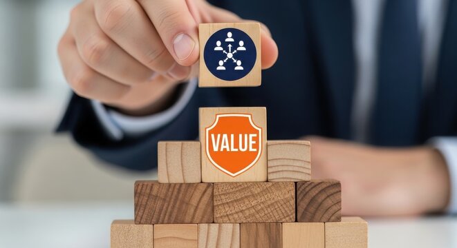 Hand placing value block on top of pyramid with teamwork icon