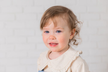 Naklejka premium portrait of a little girl with blond curly hair and blue eyes