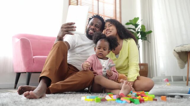Happy family enjoying playtime with tablet and toys on the floor
