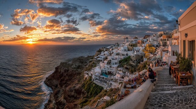 Island visitors enjoy Santorini's sunset, with its famous caldera views and colorful clouds. Romance abounds in this dream Greek cityscape.