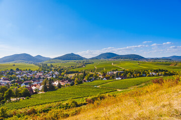 Obraz premium Vineyard landscape with hills and small town under clear blue sky during afternoon