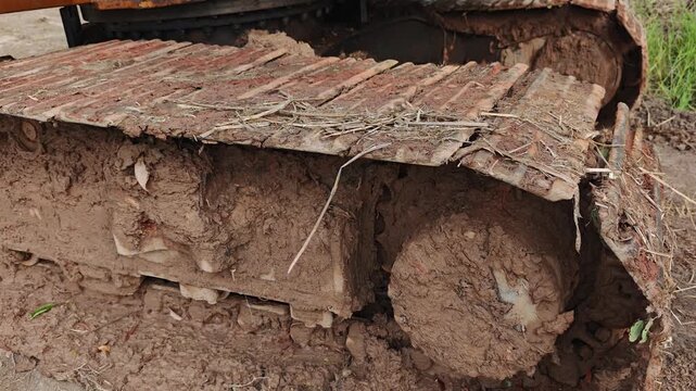 Close-up of dirty excavator tracks covered in mud.