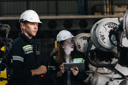 Repair specialist inspects machinery in factory ensuring industry standards are met while checking spare parts for maintenance and operational efficiency