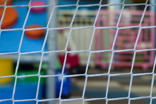 White safety net with blurred background of children's play area