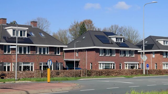 Row of luxury Dutch houses in front of a road with passing cars in Leuvenheim, The Netherlands