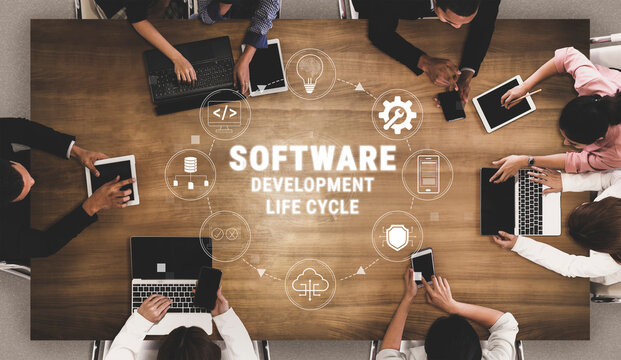 Collaborative work environment showcasing software development life cycle with diverse individuals using tablets and laptops around a wooden table Quark.
