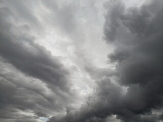 Obraz premium ​Dramatic dark storm clouds gathering in a grey overcast sky before rain.