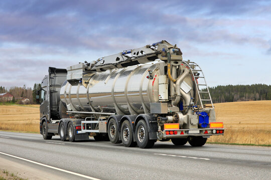 Truck Pulling Slurry Tank Trailer on Road, Rear View. 