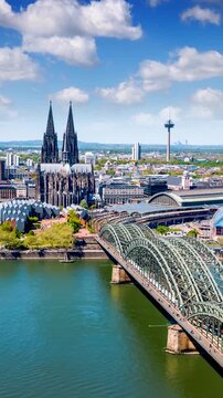 Elevated time lapse view of the cityscape of Cologne, Germany, with Cathedrale and street traffic during a sunny summer day with clouds
