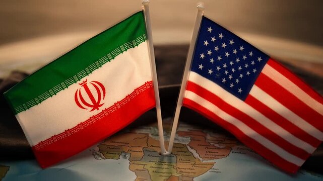 Small Iranian and American flags stand side-by-side on a world map, illustrating the complex geopolitical relationship, diplomatic tensions, or potential for dialogue between the two nations.