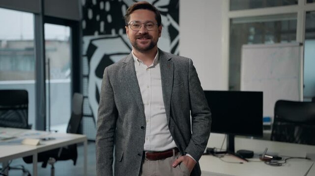 Caucasian business man smiling looking at camera businessman unbutton button on stylish formal jacket posing in office middle-aged happy satisfied adult male wearing glasses smile successful employer
