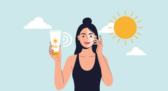 Young woman protecting her skin by applying sunscreen from a tube while standing under a bright hot sun.