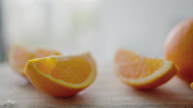 Freshly sliced oranges displayed on a wooden surface with a soft, blurred background. Ideal for concepts of freshness, health, and natural food. Close-Up of Fresh Sliced Oranges