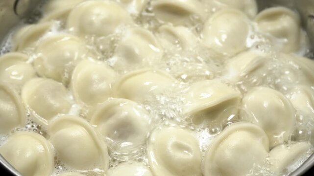 Dumplings are cooked in boiling water. The process of making homemade meat dumplings. Frozen dumplings are dropped into boiling water, stirred, and brought to a boil. Homemade semi-finished products