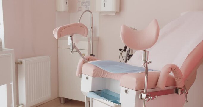 Modern Gynecologist Office with Comfortable Examination Chair. A well-equipped, pink-themed gynecologist's office featuring a modern examination chair and medical equipment.
