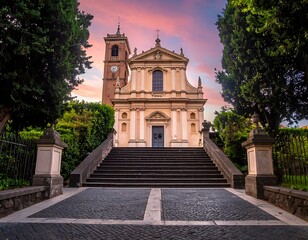 Fototapeta premium Formal facade of a European church, flanked by trees and accessed by grand stone stairs, bathed in sunset glow