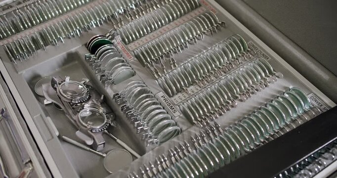 A comprehensive set of lenses and tools displayed neatly in a trial frame case often used by optometrists for eye tests. Detailed View of an Optometrist's Lens Trial Case
