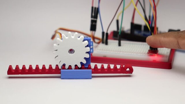 Micro servo motor running a gear and slider mechanism controlled by a micro controller on the background