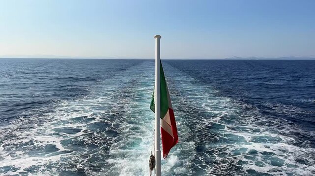 A view of the wake left by a moving ship, seen from the stern. A flag is waving in the centre of the frame