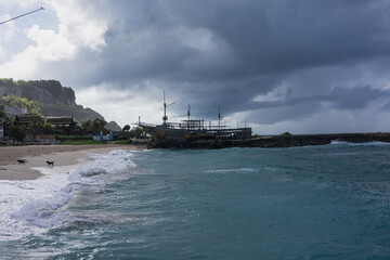 Obraz premium Pantai Melasti beach with storm clouds and ship, Bali, Indonesia
