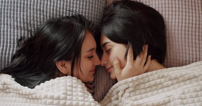 Couple of women hug each other warmly and relax at home in the bedroom. Lgbt and lesbian women at home. Embrace and holding each other. Friendship concept. Lifestyle and relationships. Couple.