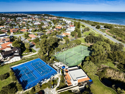 Aerial view of North Shore Community Hub and Cafe and tennis courts with people playing near residential houses and the coastline in Kallaroo, Western Australia, Australia.