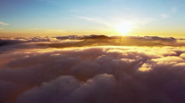 Sun shining brightly above white fluffy clouds at sunrise