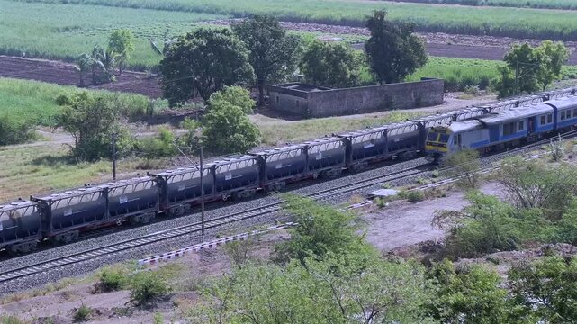 Aerial view of a local suburban commuter train in the countryside  near Pune India.