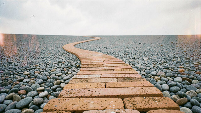 Winding brick path through pebble field conceptual journey background