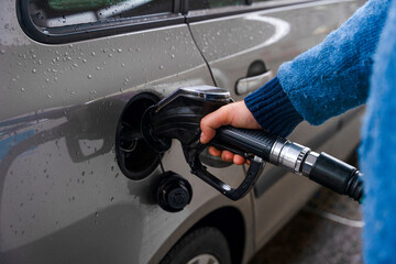 Filling up a car with gas at a station on a rainy day in the morning © Iryna