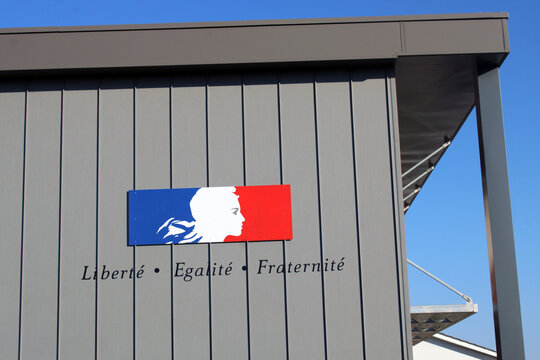 Panneau affichant la devise &laquo; Libert&eacute;, &Eacute;galit&eacute;, Fraternit&eacute; &raquo; avec la Marianne et les couleurs bleu, blanc, rouge, appos&eacute; sur la fa&ccedil;ade d&rsquo;un b&acirc;timent public (&eacute;cole, coll&egrave;ge ou lyc&eacute;e).