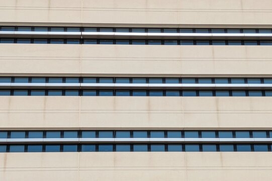 Fondo con vista de cerca de fachada moderna de edificio de oficinas con paneles de metal y hormig&oacute;n y ventanas de cristal 