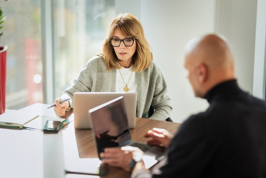 Group of business people having business meeting in a bright conference room