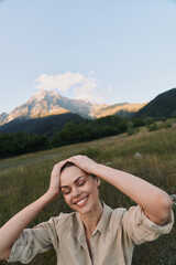 Obraz premium Meadow scene with a smiling woman in a beige shirt, hands on her head, sunlit grass swaying, conveying a relaxed outdoor lifestyle