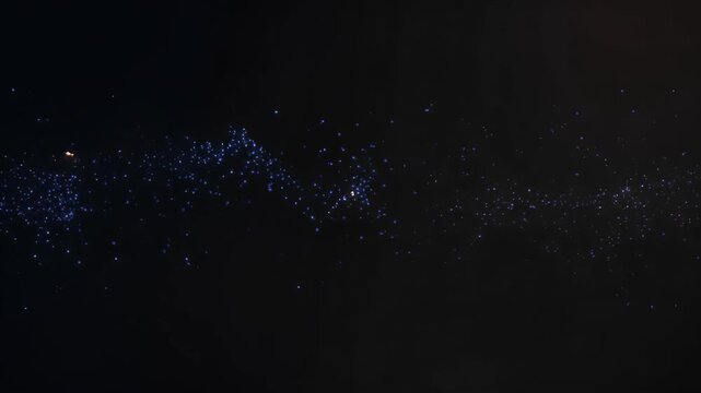 Dynamic golden particles with blue speckles create complex geometric rhombus and hexagon shapes on dark abstract digital animation background Father's Day holiday concept