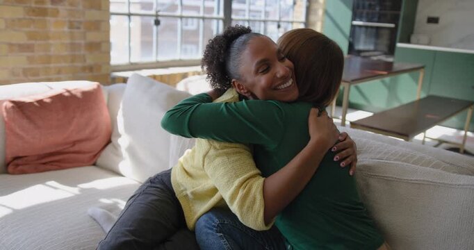 Female Friends at Home on Sofa Hugging