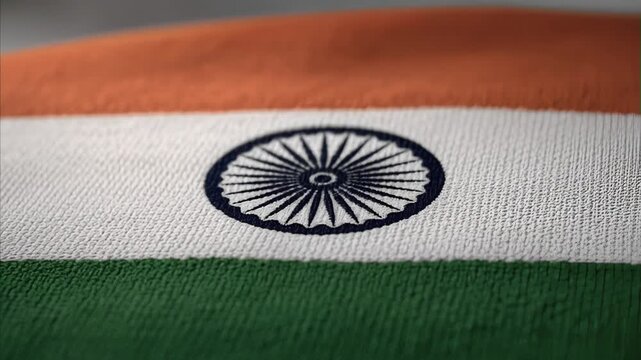 Close-up fabric detail of Indian national flag showing saffron, white, and green stripes with blue Ashoka Chakra wheel, symbolizing national pride and sovereignty of India
