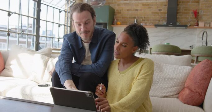 Couple Collaborating Over Digital tablet, Looking at Home Finances