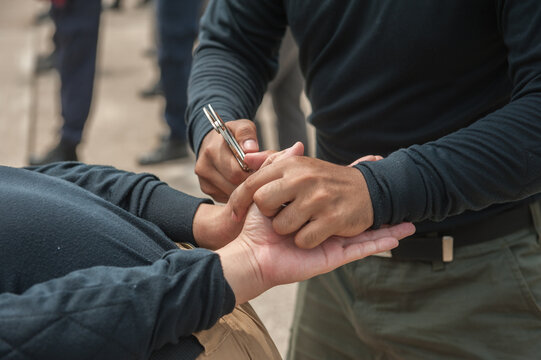 Police demonstrate how to use handcuffs to restrain suspects or prisoners.