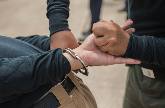 Police demonstrate how to use handcuffs to restrain suspects or prisoners.