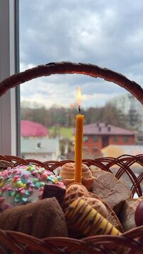 Wicker Easter basket with traditional food and burning candle