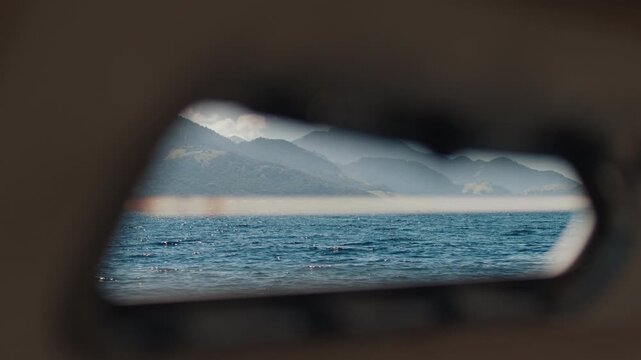 Island of Ilha Grande in Brazil as seen through the illuminator of the moving sailing boat