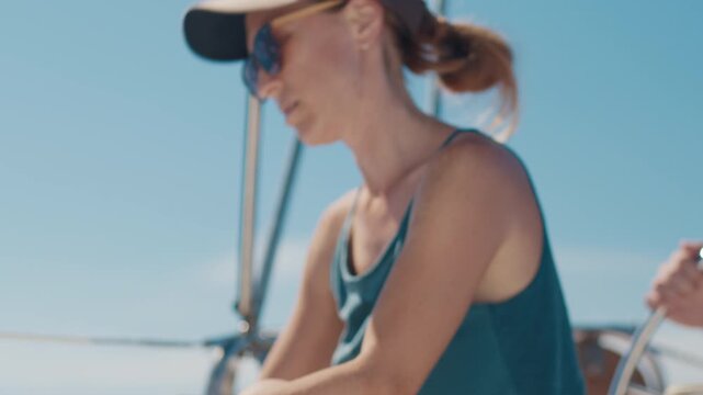 Woman sailor works with rope on a sailing boat. Couple sailing in the tropical calm sea during nice sunny day