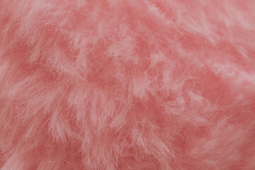 Soft pink plush fabric background with long fuzzy fibers, macro shot of delicate textile surface for romantic design or beauty backdrop © moryachka