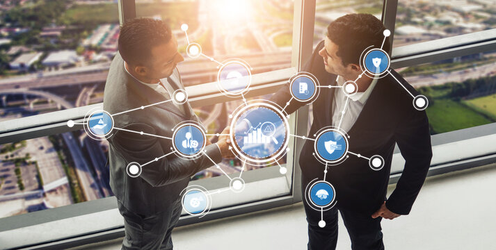 Two business professionals engage in a handshake while surrounded by digital icons in a modern office, symbolizing partnership and collaboration in today corporate world. Tessel